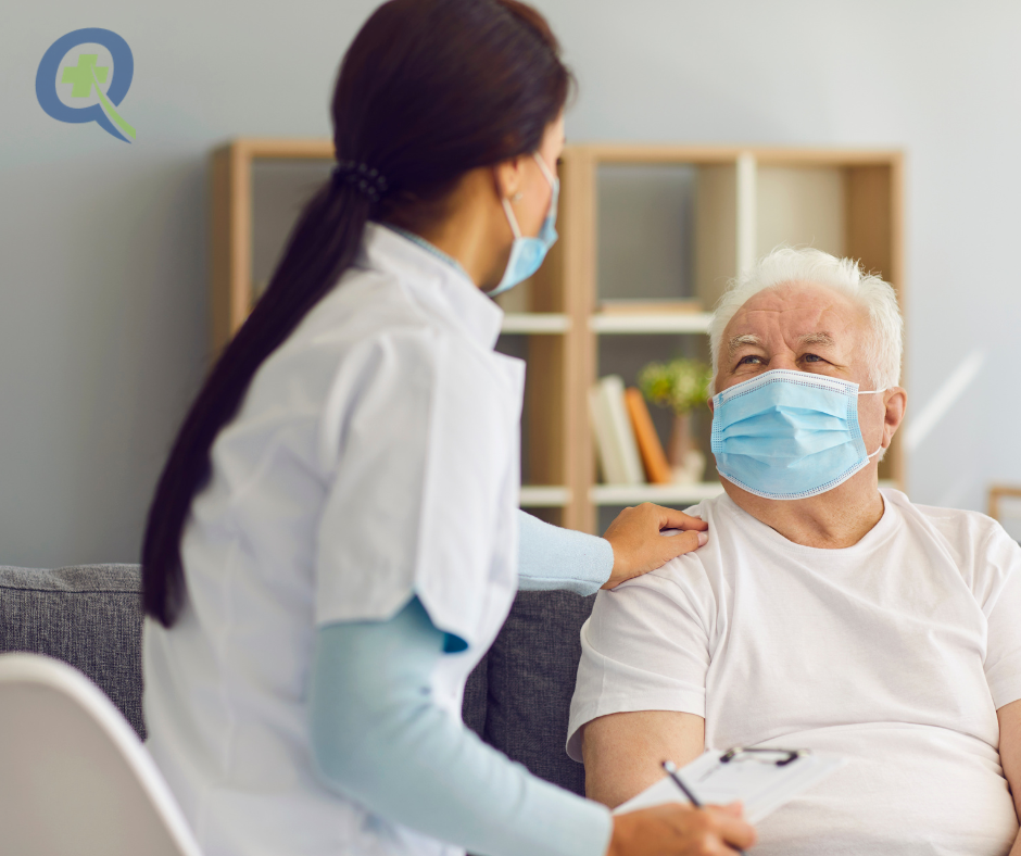 Healthcare provider consulting with patient about C. diff risk factors, hands clasped on desk with medication and laptop visible