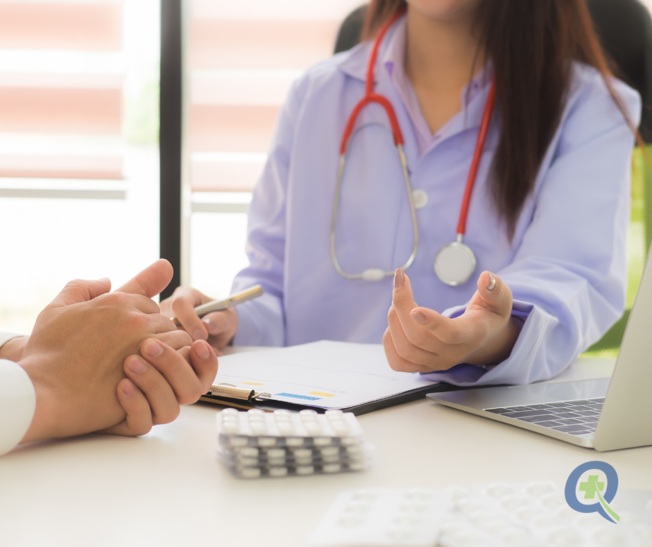 Healthcare provider educating patient about C. diff treatment with medication blister packs visible on desk and QuickRx logo