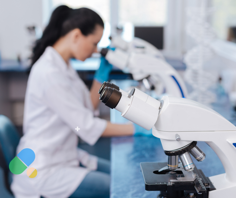 Female scientist in white lab coat working with microscope in modern laboratory, representing ongoing gene therapy research for AMT-130 Huntington's disease treatment approaching FDA approval
